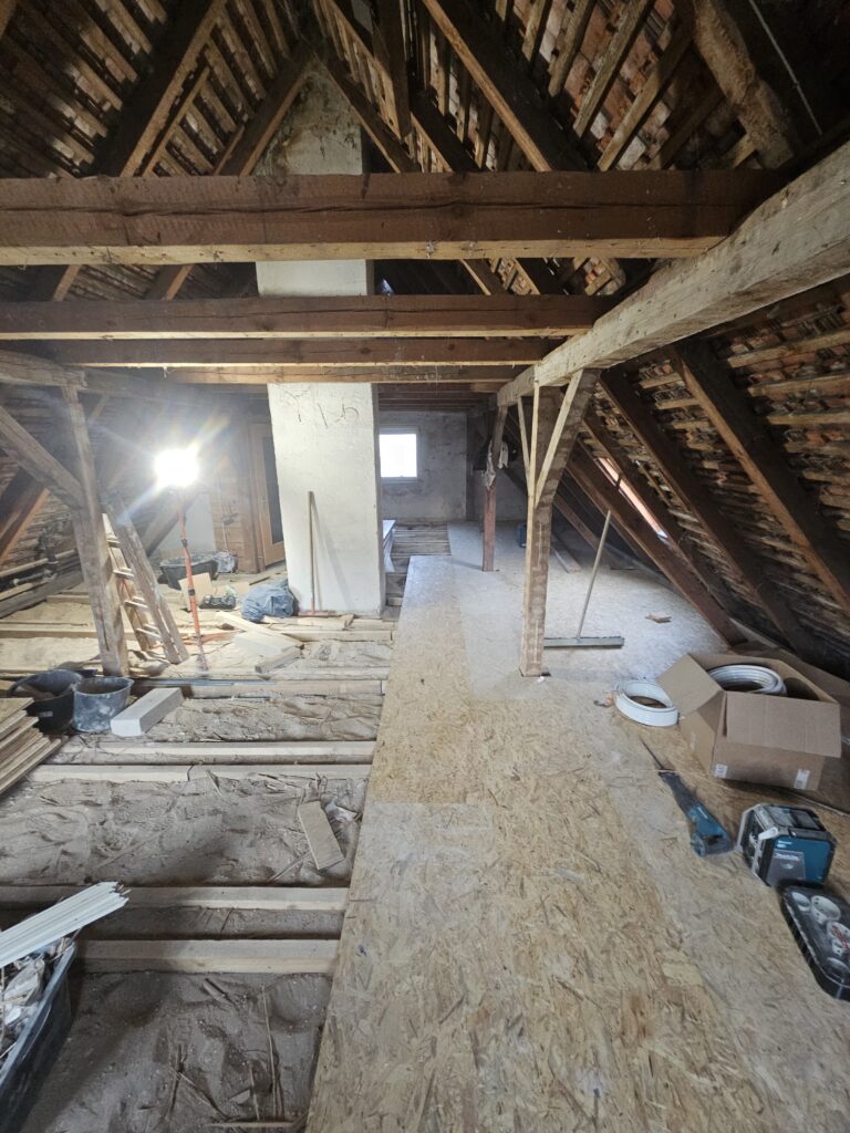 Dachgeschoss im Umbau mit Leiter an der Wand während der Renovierung.